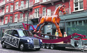  A child poses on a giant two-storey tall rocking horse outside Christies auction house in London on Monday. The Rocking Horse is expected to sell for 25,000-40,000 when it is auctioned at the Christie's Out of the Ordinary sale on September 5. 