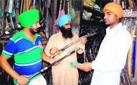 Residents haggle over prices of sharp-edged weapons at a shop in Amritsar on Tuesday