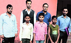 Members of the Child Line, a children's helpline, rescue three children from a dhaba at Sundernagar in Mandi on Saturday
