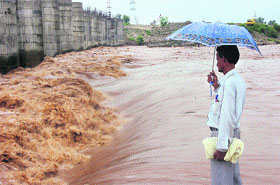 A man looks at the rising water level in Tawi after downpour in Jammu. 