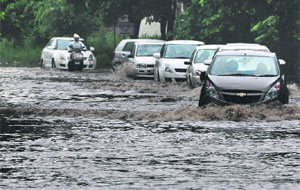 Vehicles pass through a waterlogged road at Sarabha Nagar in Ludhiana. 