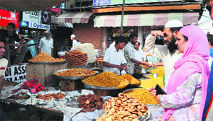 People are busy buying snacks ahead of Eid-ul-Fitr in Srinagar on Wednesday.