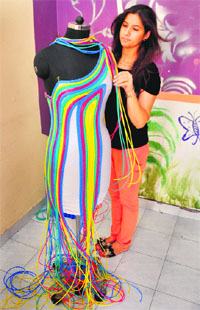A student of the PIFT showcases a dress designed by her for the upcoming annual fashion show. 