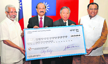 Ambassador Tien Chung-Kwang (2nd R), Representative of the Taipei Economic and Cultural Center in India presents a cheque for $50,000 to Editor-in-Chief of The Tribune Raj Chengappa (3rd R) as contribution towards the Prime Ministers Relief Fund for Uttarakhand flood victims.