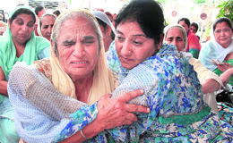 Grieving mother of the realtor being consoled by a relative in Kapurthala on Wednesday.