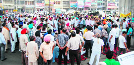 Members of the Property Dealers Association protest near the bus stand in Amritsar on Thursday.