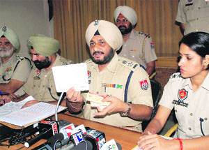 SSP Ravcharan Singh Brar shows fake registration certificates of vehicles during a press conference in Bathinda on Thursday. 
