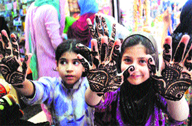 Girls show their palms coloured with mehendi, at Maharaji Bazaar in Srinagar.