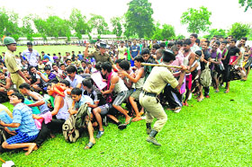 Paramilitary personnel control candidates waiting in line for a physical fitness test during a recruitment rally for the Tripura State Rifles in Agartala on Thursday.