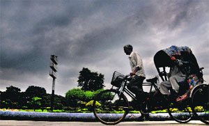 A rickshaw-puller paddles against the backdrop of an overcast sky on the Sector 22/23 roundabout in Chandigarh on Friday. 