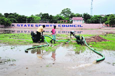 Workers pump out water from the Parade Ground in Jammu on Friday.