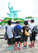 Young boys pray at the Peace Statue at the Peace Memorial Park in Nagasaki, western Japan on Friday.