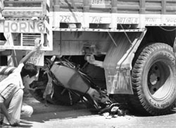 A boy takes a look at the motorbike that was crushed under a truck on the Ambala-Chandigarh highway in Zirakpur on Saturday