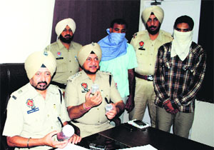 ADCP Joginder Singh along with the murder accused during a press conference in Ludhiana on Saturday. 