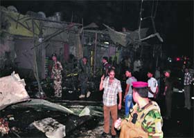 Iraqi security forces inspect the site of a car bomb attack in Nasiriyah city, south of Baghdad, on Saturday