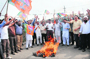 Bharatiya Janata Yuva Morcha (BJYM) activists burn an effigy of Prime Minister Manmohan Singh on Jalandhar-Jammu National Highway.