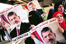 Supporters of ousted Egyptian president Mohamed Mursi hold posters during a demonstration in Cairo