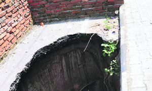 A huge pit on the Sector 64/67 dividing road in Mohali due to a cave-in.