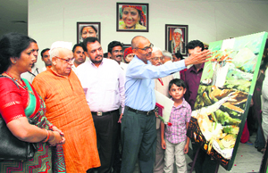 Governor Aziz Qureshi looks at a painting at the closing ceremony of a three-day art exhibition at Raj Bhavan in Dehradun on Monday.