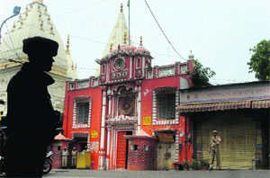 Security forces personnel stand guard outside the Raghunath Temple in curfew- bound Jammu. 