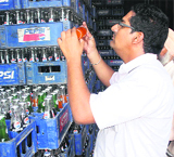 Members of a district Health Department team collect samples from bottles of a soft drink from a dealer during a raid in Amritsar.