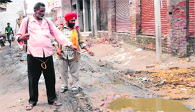 Health Department employees spray medicines at Ram Nagar Colony in Amritsar on Tuesday.