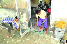 Canteen workers pick pieces of a shattered glass door after two groups of students clashed inside the boys canteen of Government Rajindra College in Bathinda on Tuesday