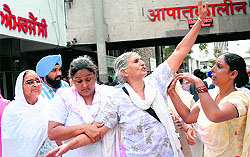 Women protest in front of the main gate of the hospital