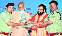 Mahant Ravindra Puri and Mahant Ramanandapuri Maharaj honour SSP Rajeev Swaroop and circle officer Jodh Ram Joshi in Haridwar on Tuesday