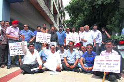 Traders hold a protest in support of their demand for the reversal of tri-monthly filing of trade tax returns in Dehradun on Tuesday. 