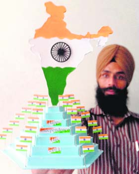 Paper artiste Gurpreet Singh displays his model of the Tricolour on the eve of Independence Day in Amritsar on Wednesday