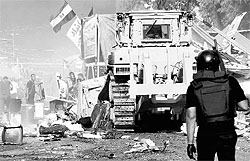Egyptian security forces, along with bulldozers, move in to disperse a protest camp held by Mursi supporters in Cairo on Wednesday