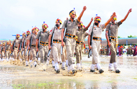 A police contingent splashes across a puddle during the march past.