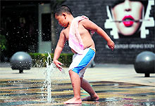 A boy plays in fountain to cool off in Beijing
