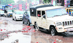 Vehicles passing through a potholed road in Amritsar on Saturday. Photo: Vishal Kumar
