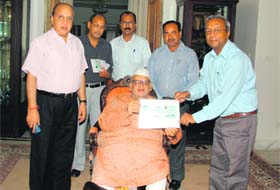 Alok Jain, acting Vice-Chancellor of GB Pant University, presents a cheque to Governor Aziz Qureshi for disaster relief at Raj Bhawan in Dehradun on Saturday