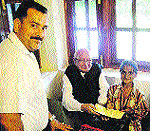 Speaker Brij Bihari Lal Butail hands over a cheque of Rs 75,000 to a woman in Palampur