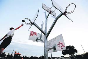 A boy throws a ball at the "Basketball Tree" (Arbre a basket), a creation by the French a/LTA architecture agency in Nantes, western France, displayed as part of the "A journey to Nantes" (Le Voyage a Nantes) art festival, running till September 1.