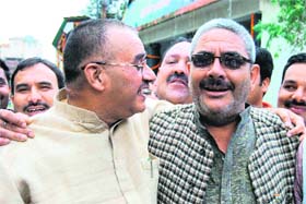Mussoorie BJP MLA Ganesh Joshi and Mussoorie Municipal Corporation chief Manmohan Mall hug each other in Mussoorie on Sunday