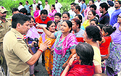 Police officers try to pacify residents protesting against the PDD at Sainik Colony in Jammu on Sunday