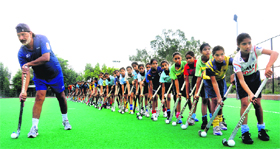 Coach Baldev Singh teaching the finer nuances of dribbling to young girls at Shahabad Hockey Academy.