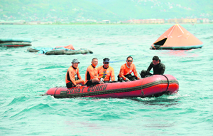 Philippine coastguard personnel survey the sea for an oil spill at the site of a sunken ferry on Sunday.