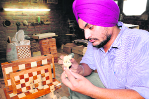 Amritpal Singh prepares a chessboard at his workshop in Amritsar.