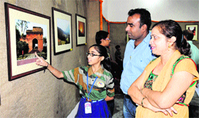A student shows a photograph to visitors at the exhibtion in Bathinda on Monday.