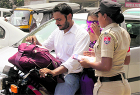 A newly recruited woman constable distributes pamphlets among commuters as part of a traffic awareness campaign in the Jagraon Bridge area in Ludhiana on Monday.