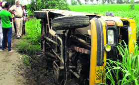 An overturned school bus near Rangian village on Monday.