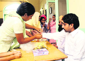 A woman ties rakhi to an inmate at the Central Jail in Bathinda on the occasion of Rakshabandhan on Tuesday.
