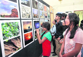 Students have a look at photos on display at an exhibition in Dehradun on Tuesday.