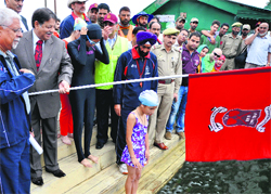 Minister for Floriculture, Haj and Auqaf Peerzada Mohammad Sayeed flags off the Annual Dal cross in Srinagar on Tuesday. A tribune photograph