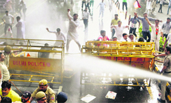 BJP workers face water cannons during a protest against the launch of food security programme in Delhi on Tuesday.  PTI